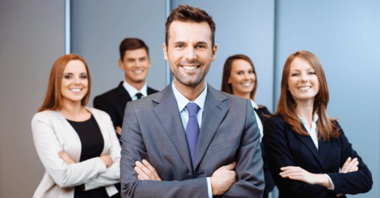 Group of business professionals in formal attire standing confidently with arms crossed, representing teamwork, leadership, and leader training in a corporate environment