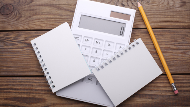 A promotional image for an online course features two smiling professionals, a man in a blue suit and a woman in a white shirt, sitting side-by-side at a desk. The man is typing on a laptop, while the woman points to the screen which displays financial charts within the "Sage 50 Accounts" software interface. Large blue text overlaying the image reads "SAGE 50 ACCOUNTS ONLINE COURSE" with the tagline "Master your business finances" below it. A small blue banner in the top left corner says "FEATURED". The background shows a bright, modern office with large windows overlooking a city skyline.