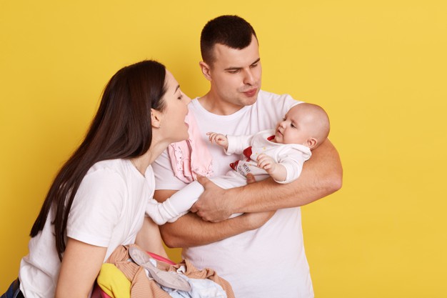 Happy couple embracing and looking at a baby