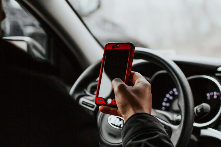 Man holding a mobile inside a car
