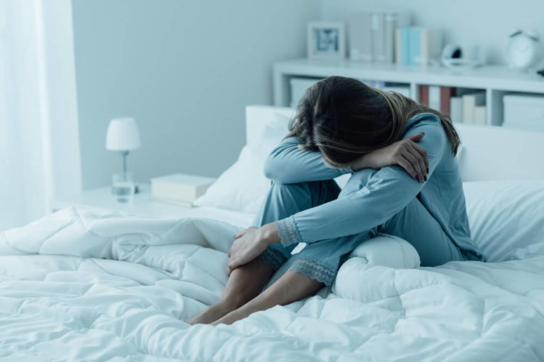 Depressed woman crying in bed