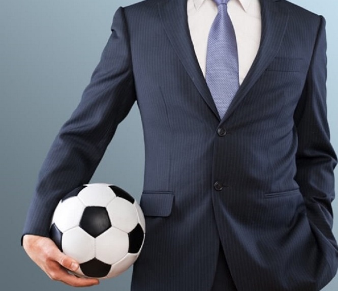 Man in suit holding a football