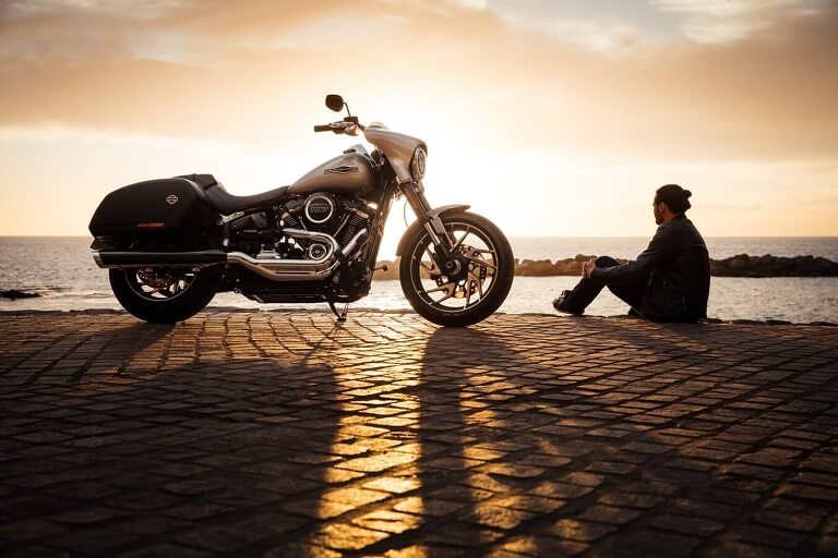 Man sitting beside a motorcycle