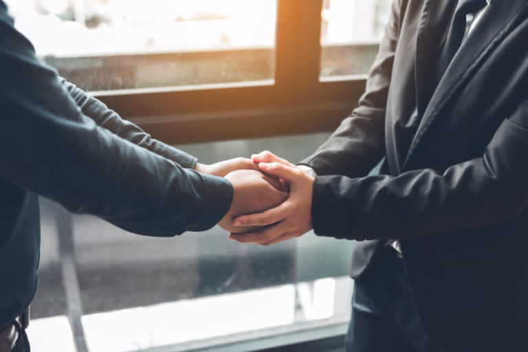 Business people compassionately holding hands at office room, assertive communication skills activities