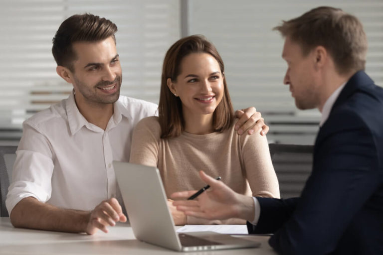 Smiling young family couple consulting with lawyer