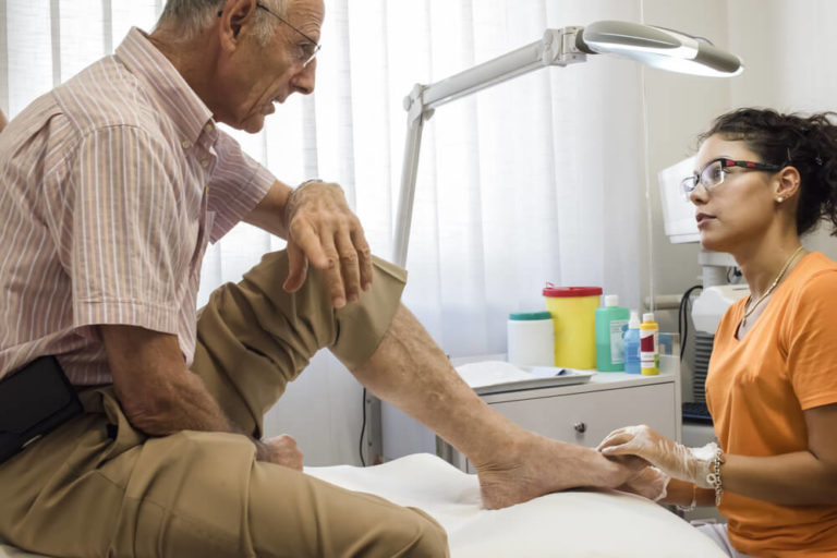 podiatry doctor curing an elderly patient feet