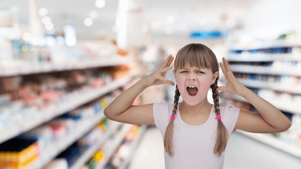 A girl is screaming in a shop, displaying a particular behavior.