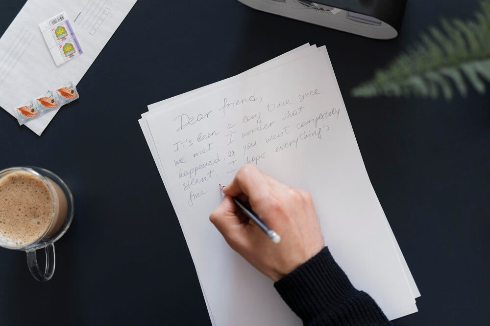 Personal storytelling written on paper on a table, with a cup of coffee beside it