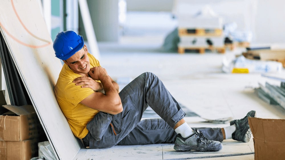 Worker holding chest in pain, illustrating the importance of method statements in construction to ensure safety and manage risks.