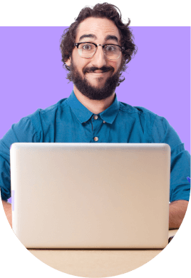 a man smiling in front of a laptop