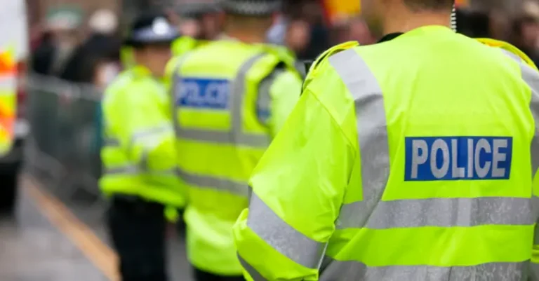 Back view of a police officer with 'Police' written on the uniform, promoting Get Your Police Officers Training