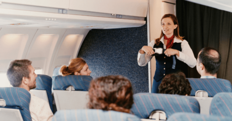 A professional flight attendant demonstrating safety procedures in an airplane cabin, showcasing the essential skills required to Become a Flight Attendant and ensure passenger safety.