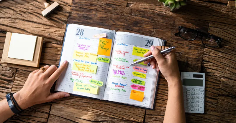 Efficient time management concept showing a calendar in use with handwritten entries and colorful task labels